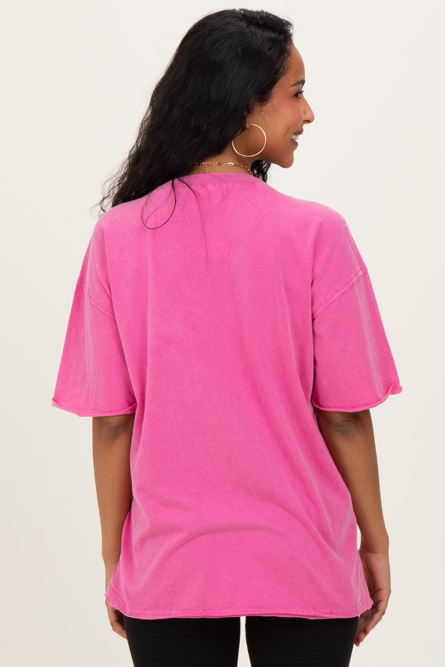 woman wearing a pink oversized maternity t-shirt, shown from the back with short sleeves and a relaxed fit