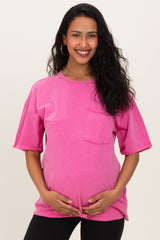 woman wearing a bright pink oversized maternity t-shirt and holding her baby bump