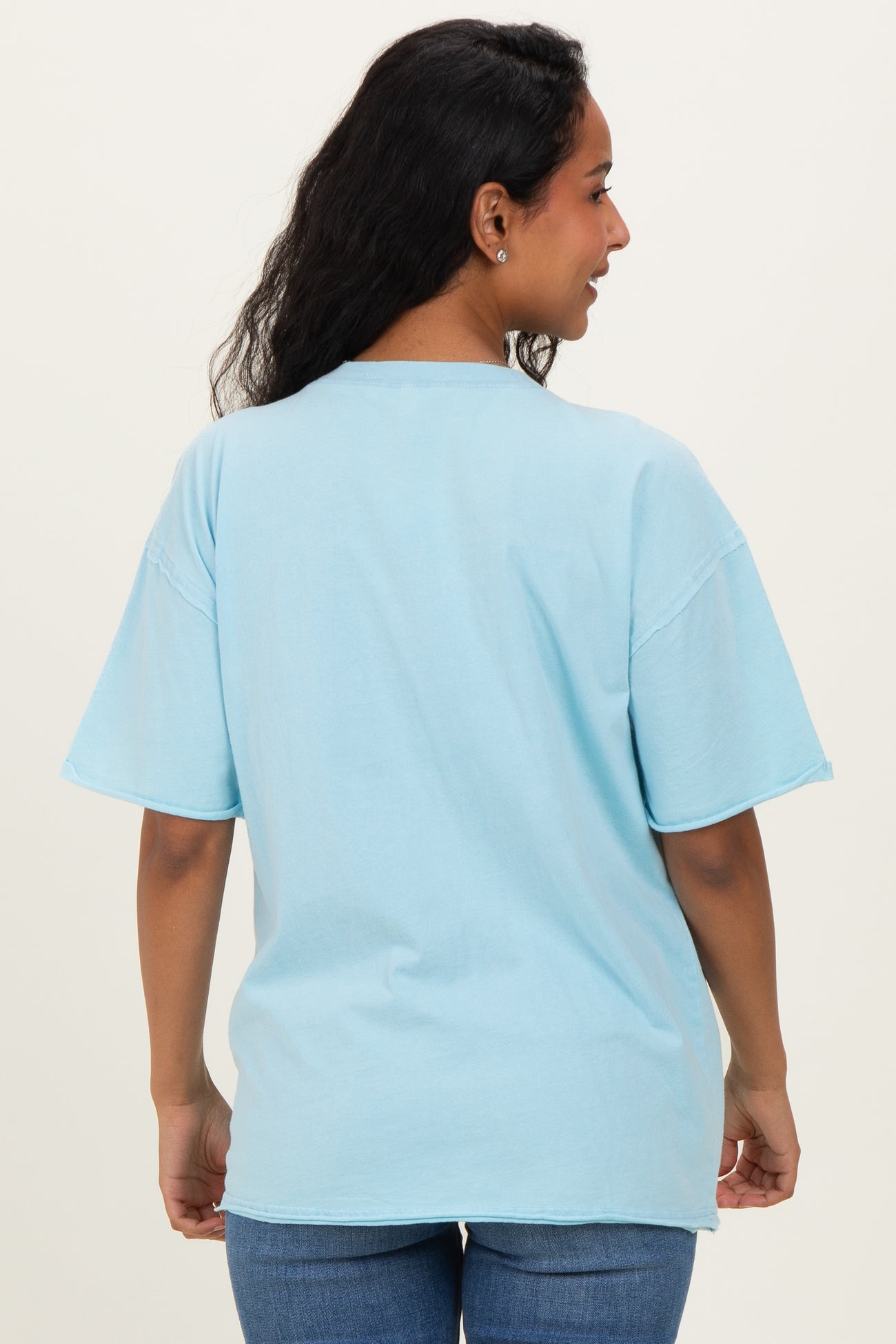 woman wearing a light blue oversized maternity t-shirt viewed from the back with short sleeves