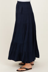 woman wearing a navy blue tiered maxi skirt with an elastic waistband and side pockets