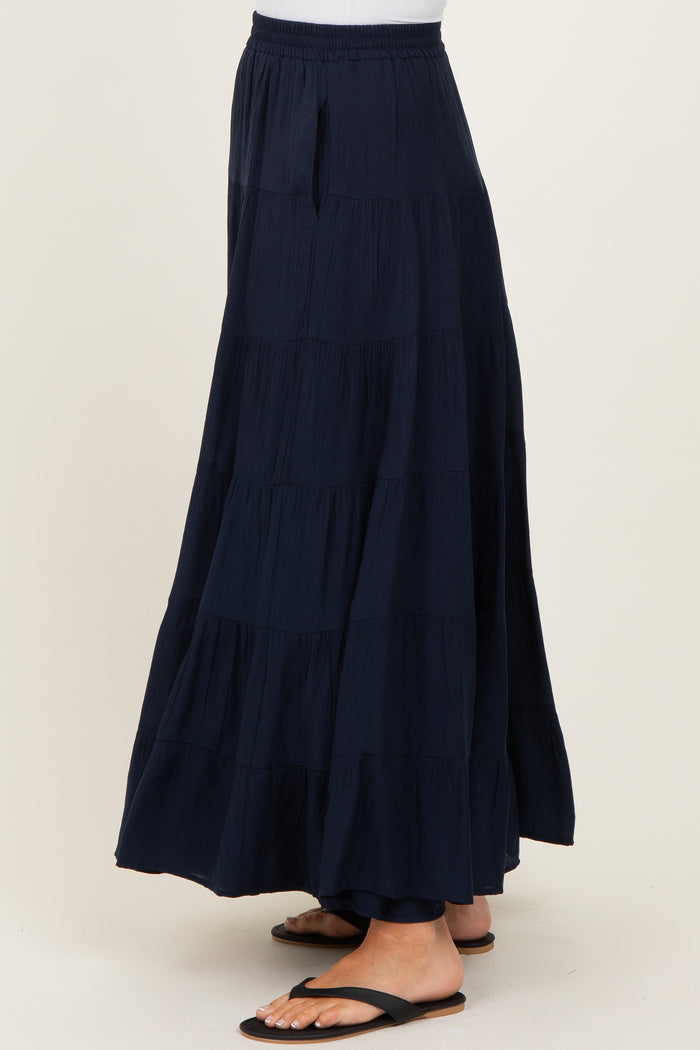 woman wearing a navy blue tiered maxi skirt with an elastic waistband and side pockets