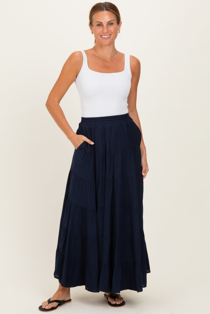 woman wearing a white square neck tank top and a long navy maxi skirt with pockets