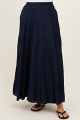 woman wearing a navy blue tiered maxi skirt with an elastic waistband and flat sandals
