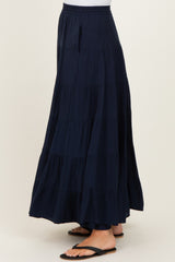 woman wearing a navy blue tiered maxi skirt with an elastic waistband and side pockets