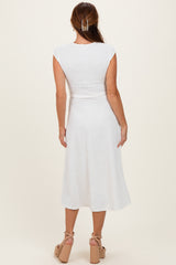 woman wearing a white cap sleeve midi dress with a textured pattern and tied waist, viewed from the back
