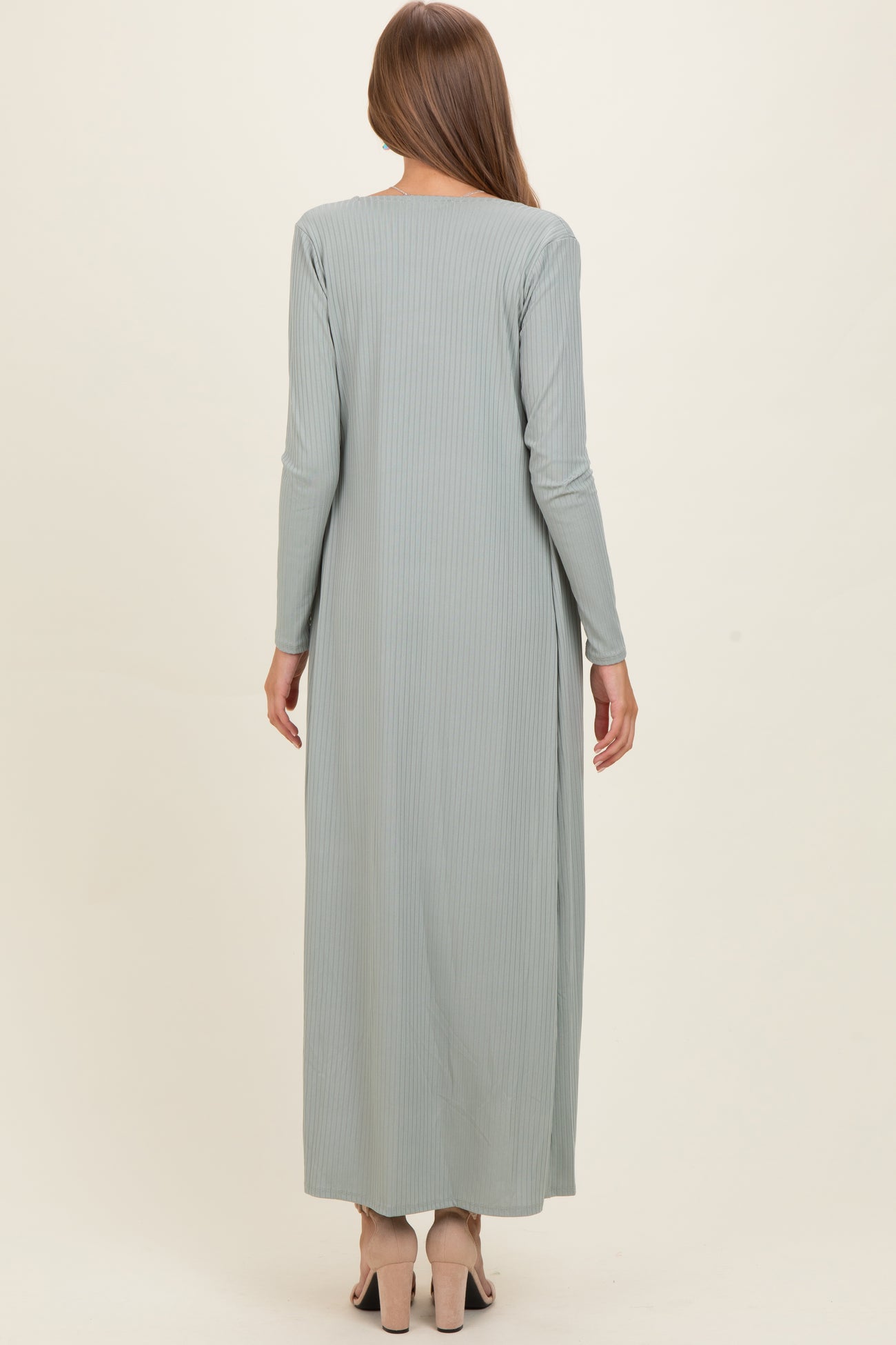woman wearing a light green long sleeve maternity maxi dress, showing a smooth, flowing silhouette from the back