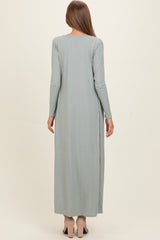woman wearing a light green long sleeve maternity maxi dress, showing a smooth, flowing silhouette from the back