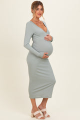 woman wearing a light green ribbed maternity dress with long sleeves and a v-neck, showing her baby bump