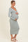 woman wearing a light green ribbed maternity dress with long sleeves and a v-neck, showing her baby bump
