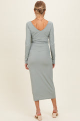 woman wearing a light green ribbed maternity dress with a v-back and long sleeves