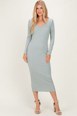 woman wearing a light green ribbed midi dress with long sleeves and a v-neckline