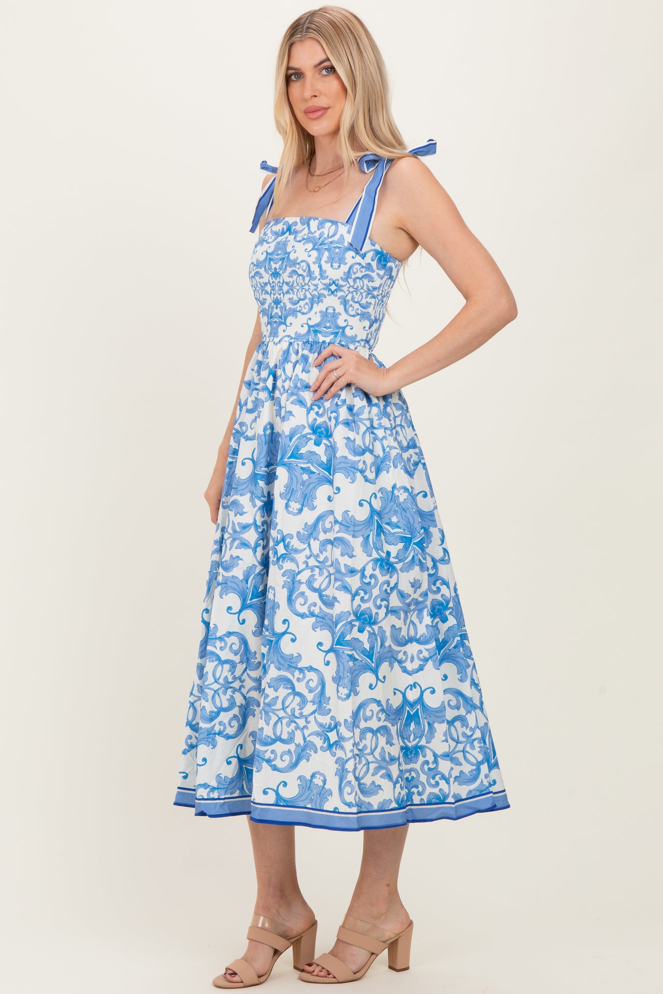 woman wearing a blue floral midi dress with square neckline and tie straps