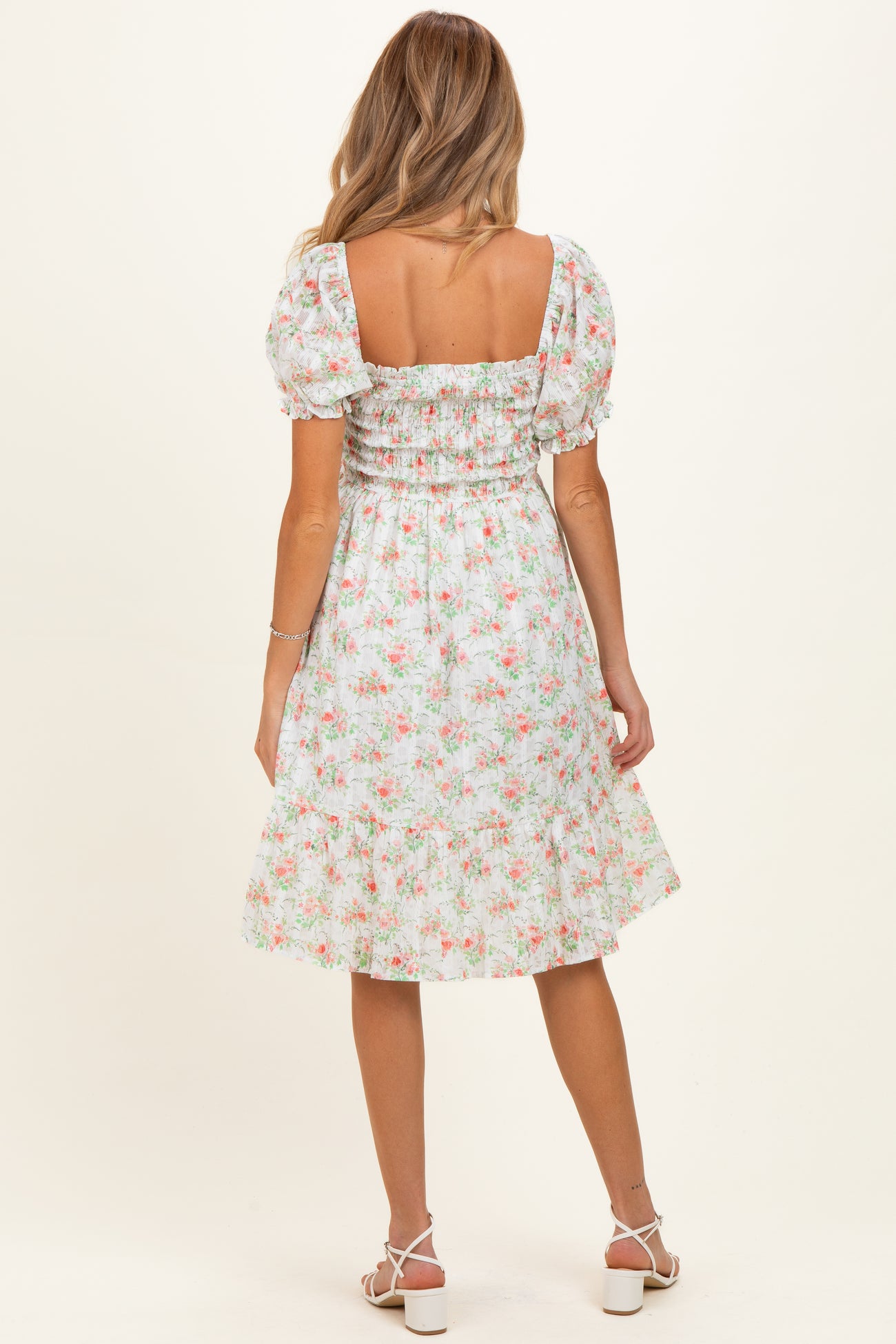 woman wearing a floral print maternity dress with puff sleeves and a square neckline, shown from the back