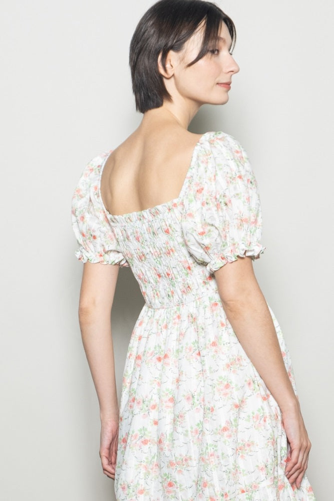 woman wearing a floral print puff sleeve dress with a smocked back and square neckline