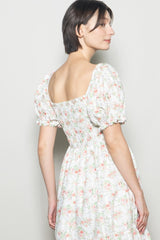 woman wearing a floral print puff sleeve dress with a smocked back and square neckline