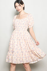 woman wearing a pastel floral print dress with puff sleeves and a square neckline