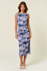 woman wearing a purple tie-dye midi dress with a scoop neckline and side slit