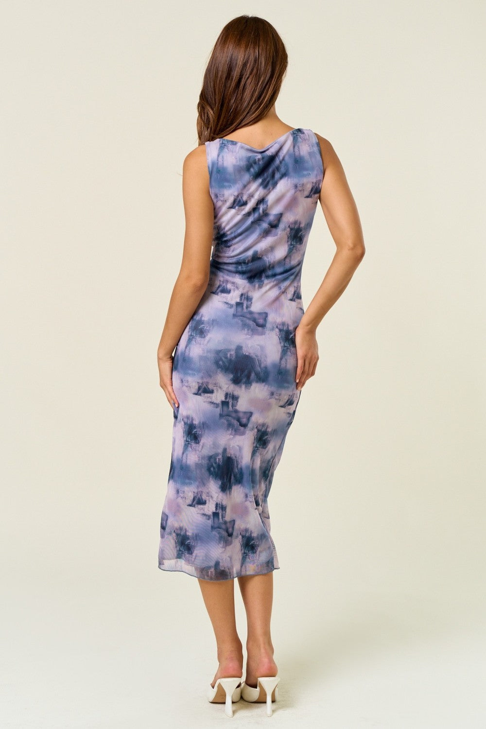 woman wearing a sleeveless purple and blue watercolor print midi dress, showing the back view