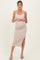 woman wearing a light beige ribbed maternity dress with a hip slit and halter neckline, showing her baby bump