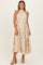 woman wearing a beige pleated halter neck dress with a floral print and a tied waist detail