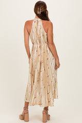 woman wearing a back view of a floral-print midi dress with a halter neck and pleated fabric
