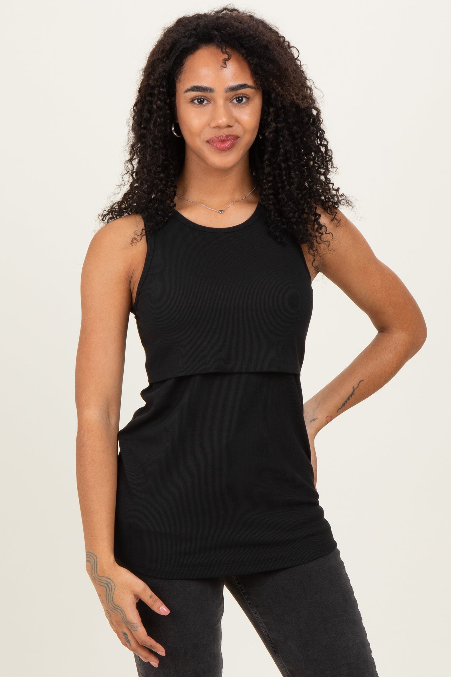 woman wearing a black sleeveless ribbed top with a layered design