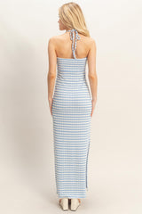 woman wearing a backless light blue and white striped maxi dress with a halter neck tie