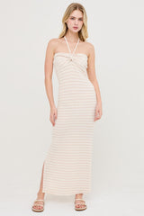 woman wearing a beige striped maxi dress with a halter neck and side slit