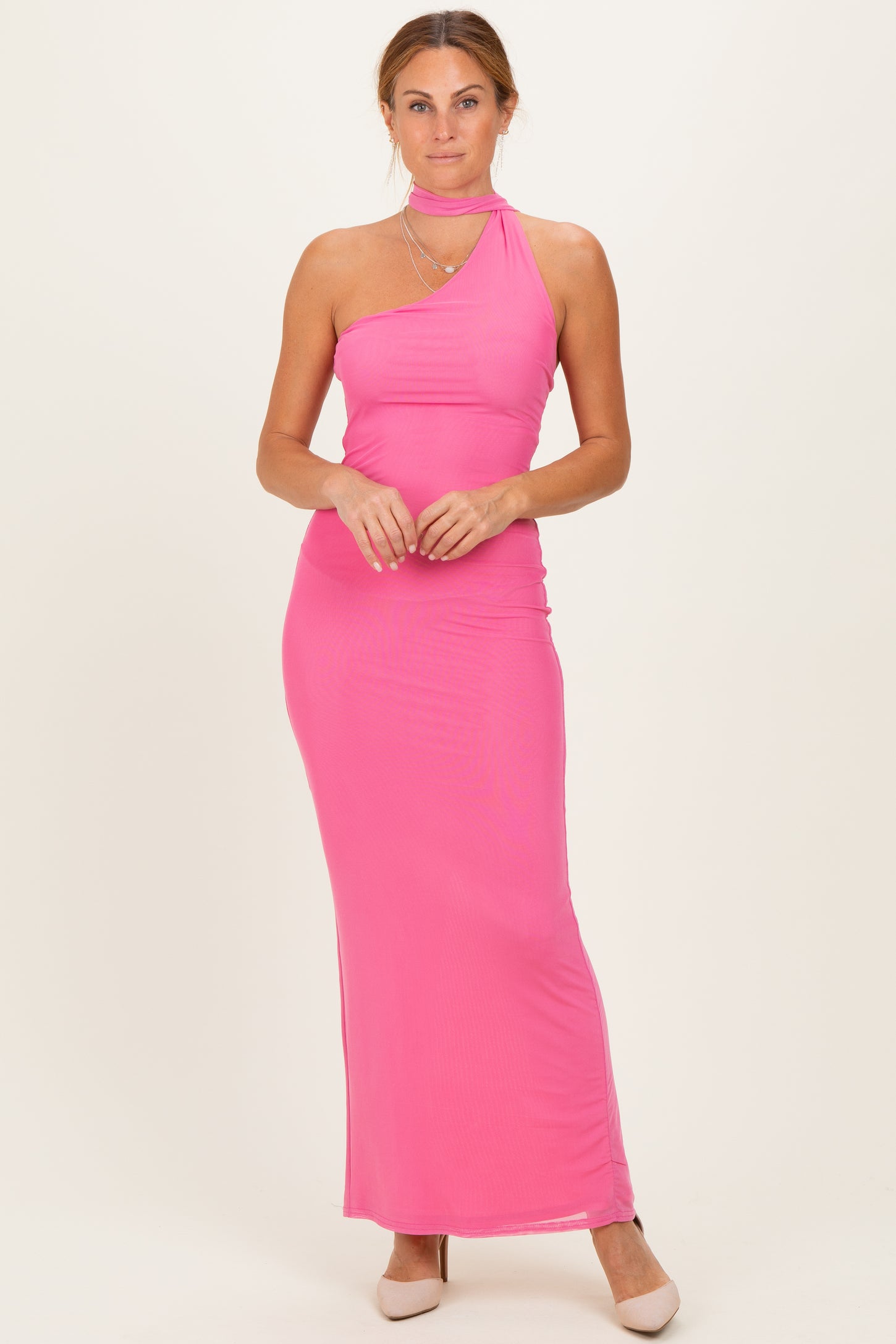 woman wearing a bright pink one-shoulder maxi dress with a fitted silhouette and a choker detail
