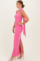 woman wearing a hot pink halter neck gown with a side slit and a flowing back tie detail