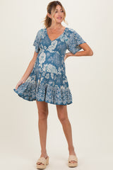 woman wearing a blue floral short sleeve maternity dress with a ruffled hem and a v-neckline