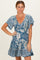 woman wearing a blue floral print dress with a v-neckline and flutter sleeves