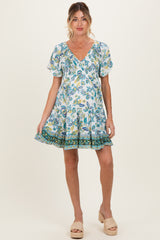 woman wearing a floral print maternity dress with short sleeves and a ruffled hem, showing her baby bump