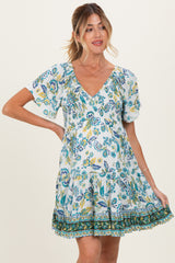 woman wearing a floral print maternity dress with short sleeves and a v-neck, showcasing her baby bump