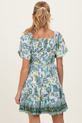 woman wearing a floral maternity dress with short sleeves and a square neckline, showing a gathered back design