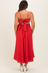 woman wearing a red maternity maxi dress with a tied back detail and a flowy silhouette