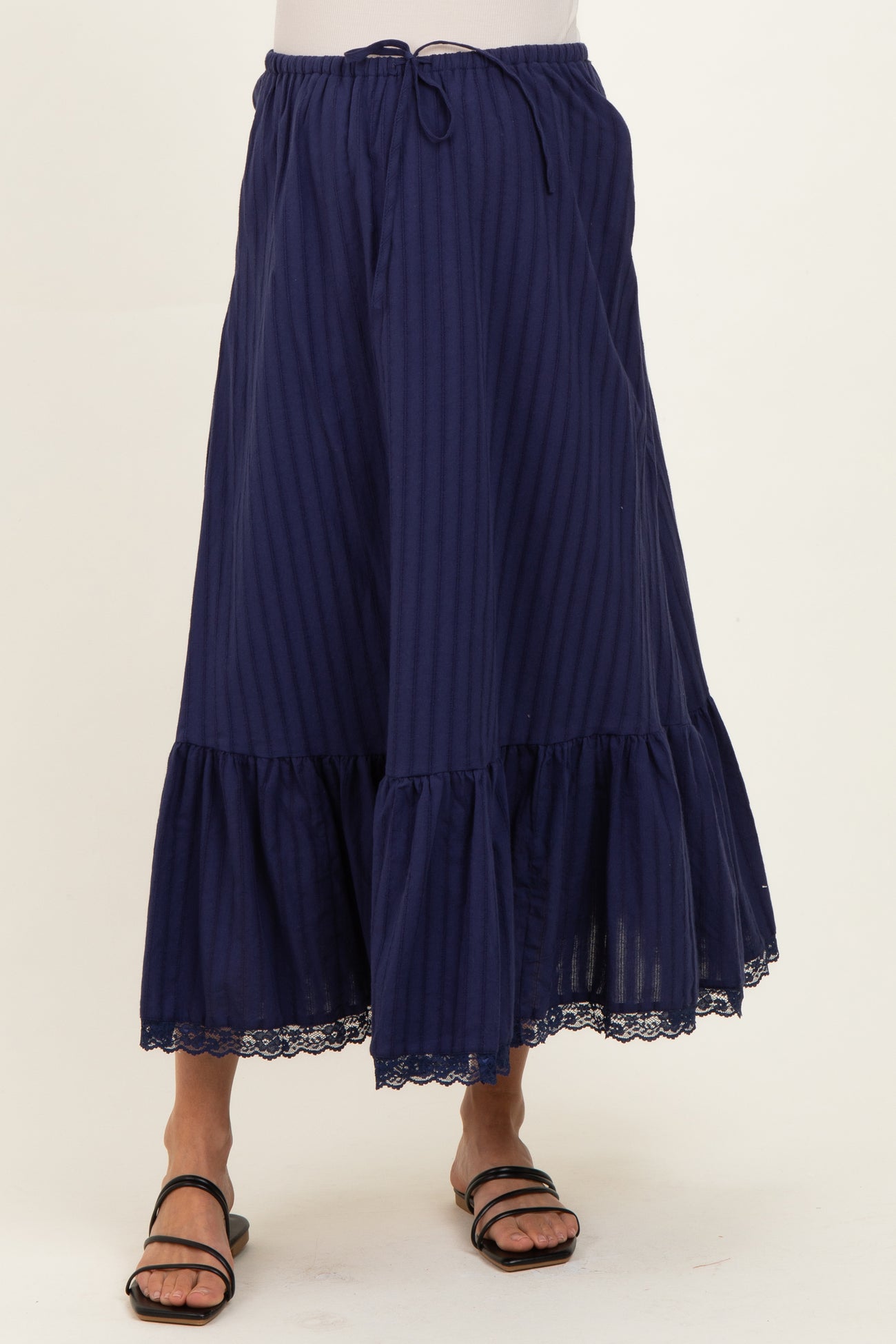woman wearing a navy blue striped maternity maxi skirt with a lace hem and drawstring waist