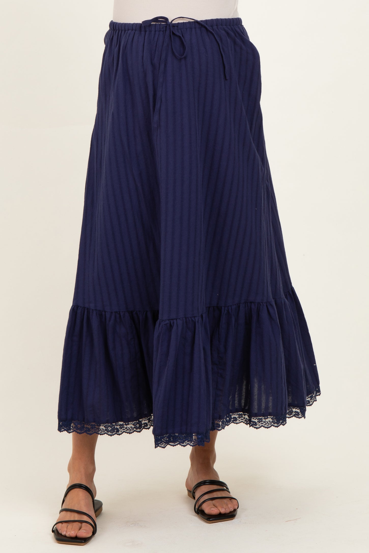woman wearing a navy blue striped maternity maxi skirt with a lace hem and drawstring waist