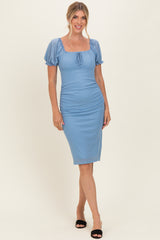 woman wearing a light blue polka dot midi dress with puff sleeves and a square neckline