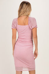 woman wearing a pink polka dot ruched dress with puff sleeves and a square back detail
