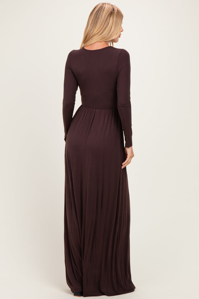 woman wearing a long sleeve brown maxi dress with a fitted bodice and flowy skirt, viewed from the back