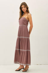 woman wearing a mauve maxi dress with spaghetti straps and embroidered detailing