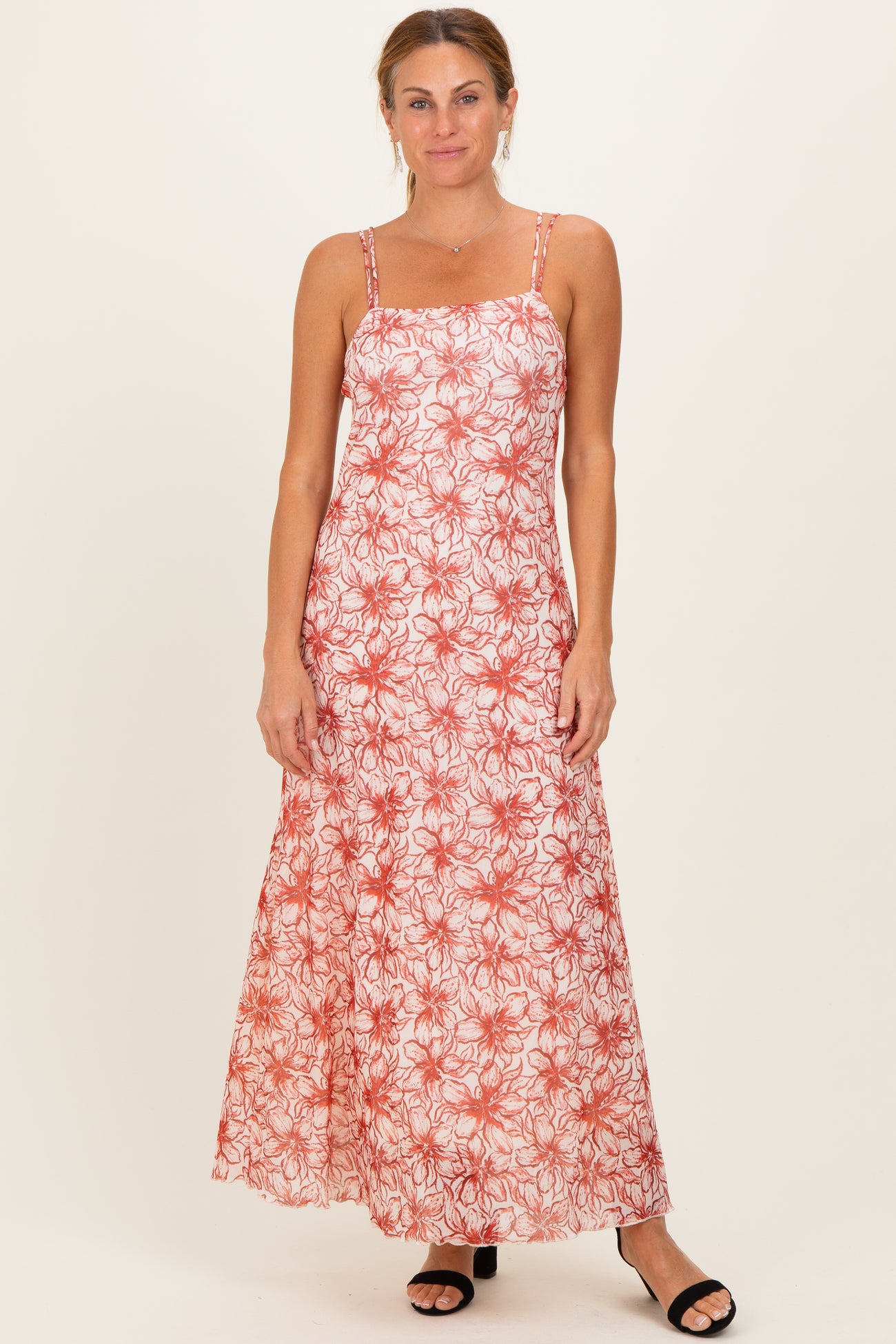 woman wearing a red and white floral maxi dress with spaghetti straps and a fitted bodice