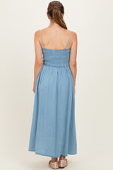 woman wearing a light blue maternity maxi dress with a smocked bodice and adjustable spaghetti straps