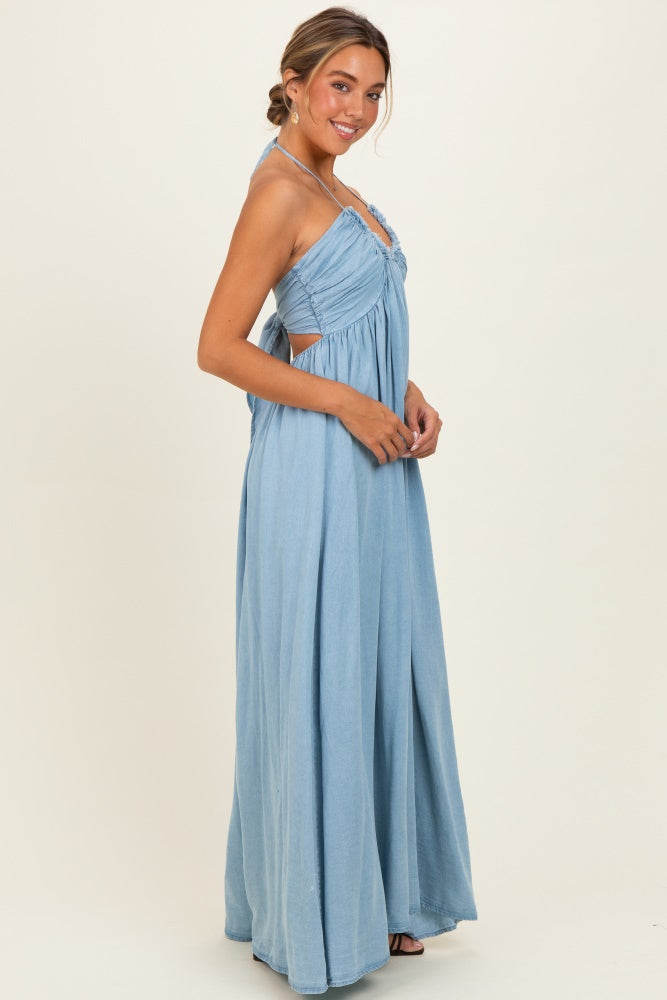 woman wearing a light blue maxi dress with cutout details and adjustable straps, posing sideways against a neutral background