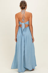 woman wearing a light blue maxi dress with a halter neck and back tie detail