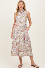 woman wearing a floral print sleeveless maternity dress with pockets and a collared neckline