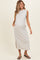 woman wearing a light grey sleeveless maternity maxi dress with side pockets and a side slit, showcasing her baby bump