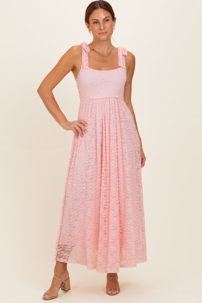 woman wearing a pink lace maxi dress with tie straps and a flowing skirt