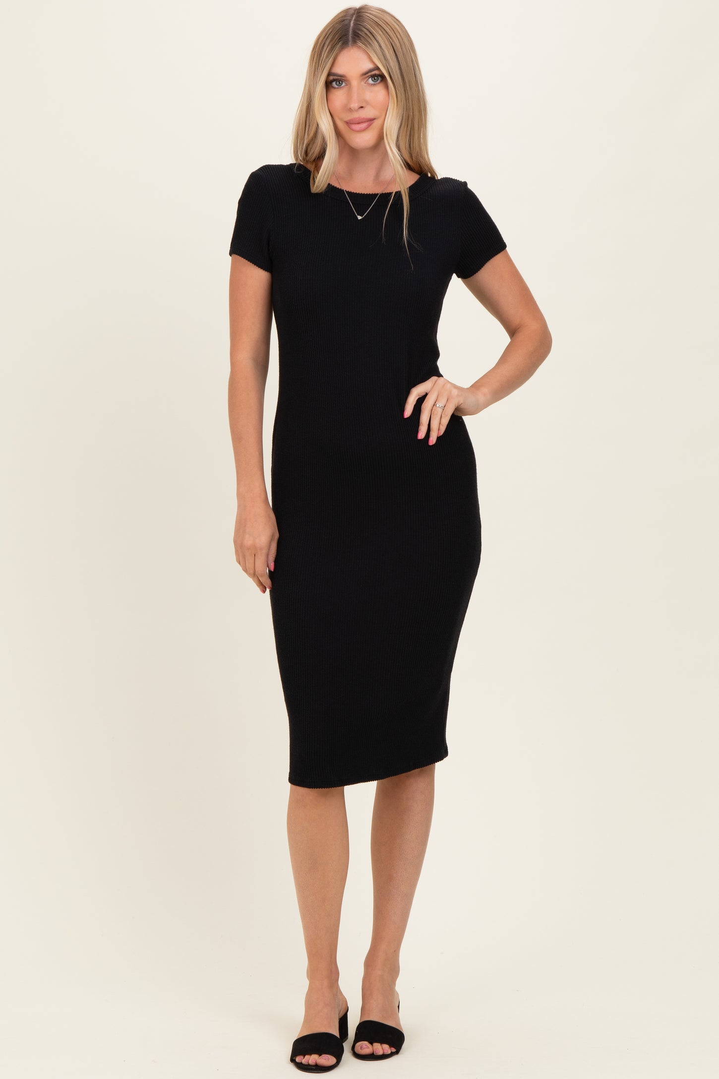 woman wearing a black ribbed midi dress with short sleeves and a fitted silhouette